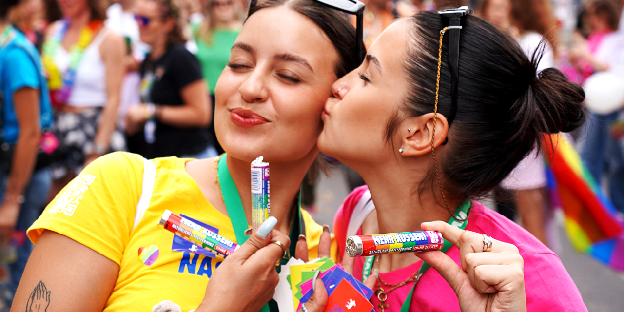 Frau küsst andere Frau auf die Wange