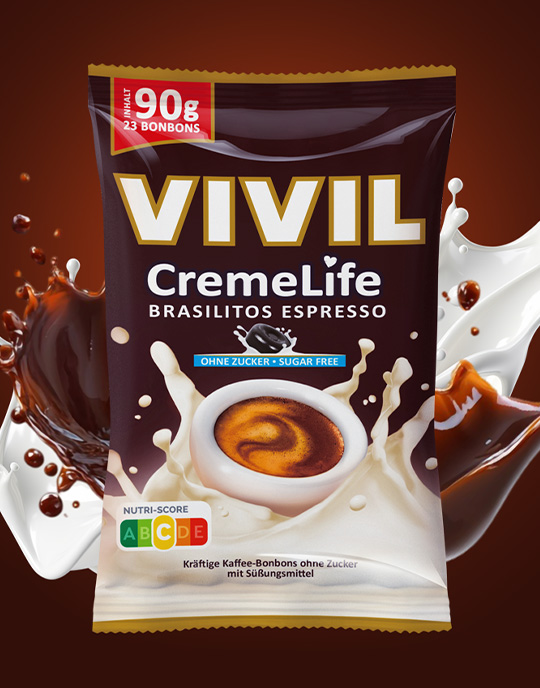 Eine Packung Vivil Creme Life Brasilitos umgeben von einem dynamischen Splash aus Kaffee und Milch