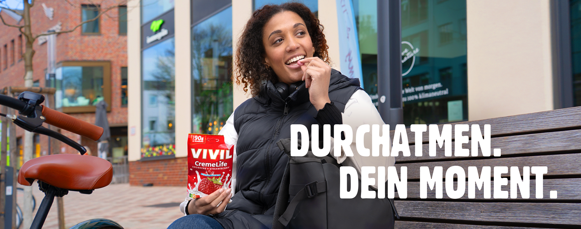 Junge Frau isst Erdbeerbonbon